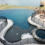 Heart shaped pool with spa and infinity edge and safety fence