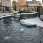 rounded spa with waterfall overflow channel into pool