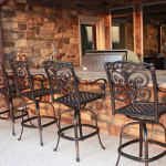 bar top of outdoor kitchen with wrought iron bar stools