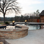 stacked stone round spa with overflow channel into pool