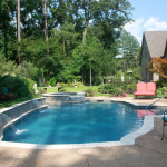 curved and rectangular pool with spa and water spouts
