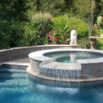 white marble rounded spa with overflow waterfall