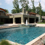 rectangular pool with water fountain shooting out of hot tub