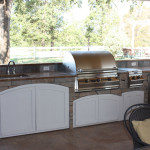 stainless steel outdoor kitchen with white rounded cabinet doors