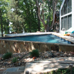 small triangular pool with large retaining wall