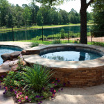 stone round hot tub with rock feature