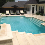 White stone pool with light blue liner and seating area