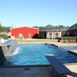 rectangular pool with spa, diving board and 3 water fountains