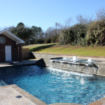 small rectangular pool with spa and water fountains