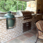 brick outdoor kitchen with green egg smoker and stainless steel grille