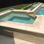 white stone square spa with cut corner overflow channel into pool