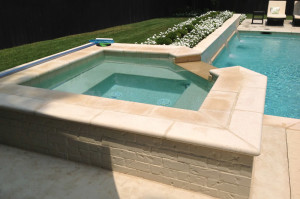 white stone square spa with cut corner overflow channel into pool